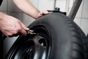 man fixing tire of a car