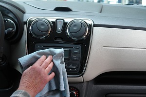 man cleaning music system of his car