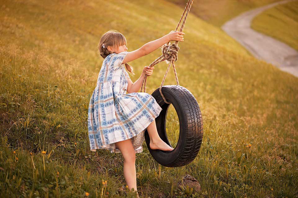 girl swinging on tire