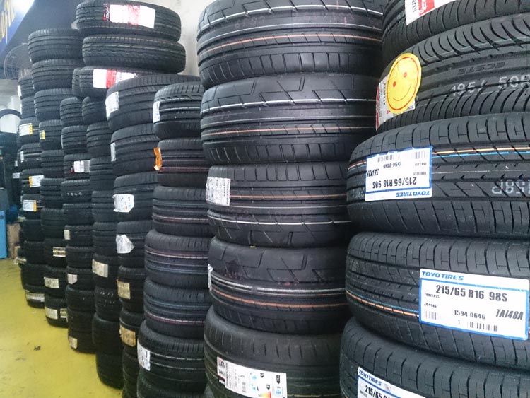 Stacks of black tires are neatly arranged in a store