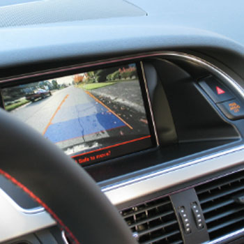 Car dashboard displaying a rearview camera screen