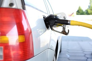 A white car is refueled at a gas station