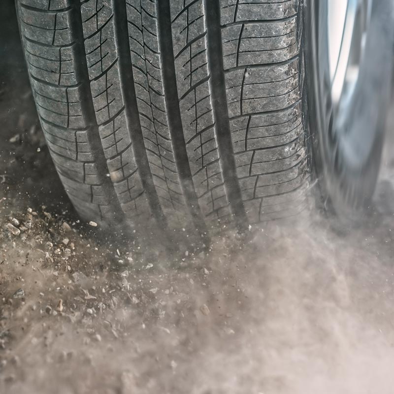 close up of car tire while driving on gravel