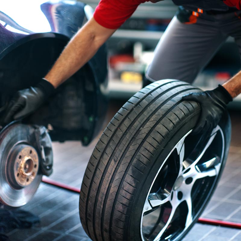 mechanic changing tires on car