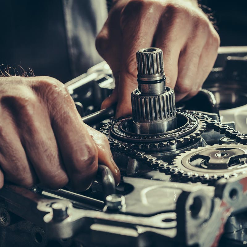 mechanic working on car transmission